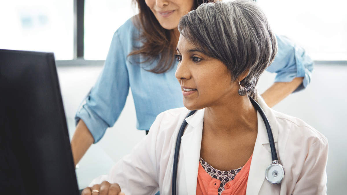 woman, possibly a doctor looking at the screen
